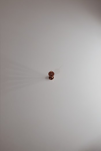 Brown Push Pin on White Surface