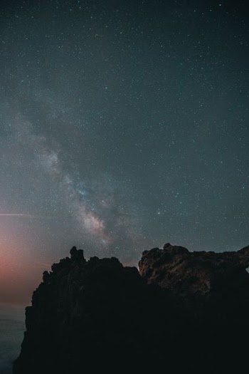 brown rock cliff under black and brown sky during nighttime