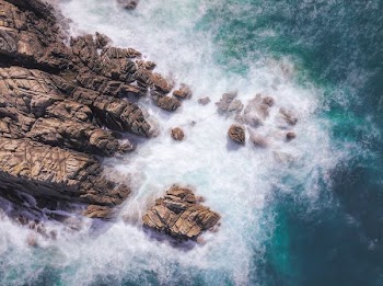 brown rock formation at the sea