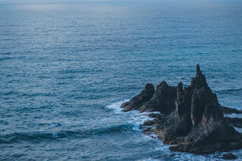 Brown Rock Formation on Body of Water
