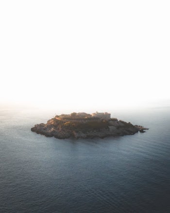 Brown Rock Formation on Body of Water · Free Stock Photo