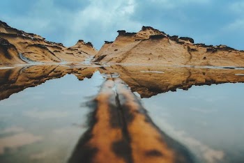 brown rock formations near body of water