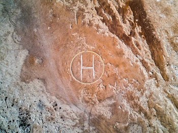 brown rock with helicopter landing area