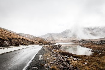 brown rocky mountain with road during daytime