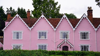 Brown Roofed Pink Two-storey Building Surrounded by Green Trees