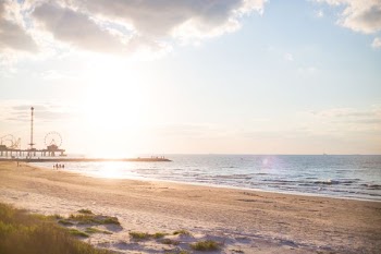 brown sand beach under blue and gray sky