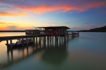 Brown Speedboat at Blue Sea Beside Brown Wooden Sea Dock during Golden Hour