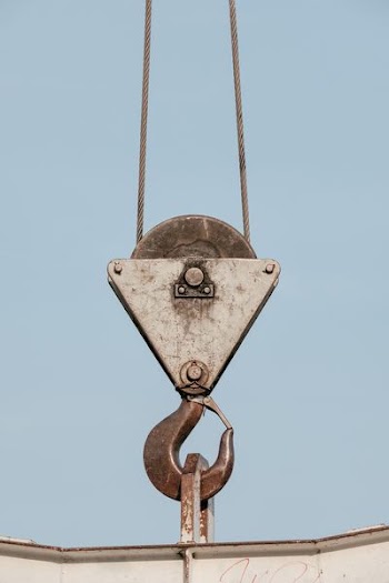 brown steel pulley holding white steel bar