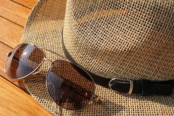 Brown Strawhat Beside Brown Aviator Sunglasses