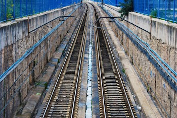 brown train rail between brown concrete wall photo during daytime