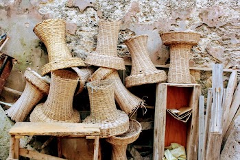 Brown Wicker Baskets and Brown Wooden Stool Beside Concrete Wall