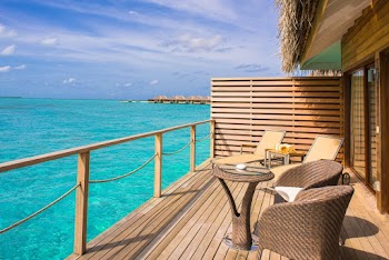 Brown Wicker Chairs and Table Beside Body of Water