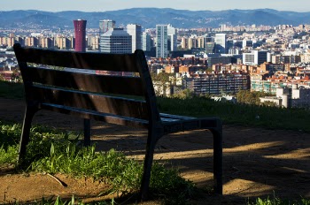 Brown Wooden Bench With Metal Frame Surrounded by Building Scenery