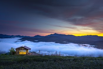 Brown Wooden Cottage With View Of Clouds And Mountain 