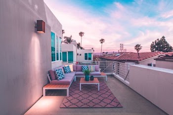 brown wooden sectional bench on top of white concrete house balcony