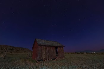 brown wooden shed on green grass field