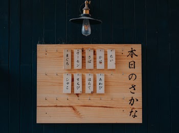 Brown Wooden Signage on Black Wooden Wall
