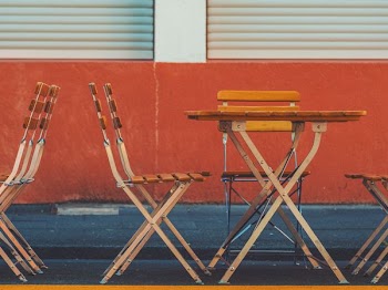 brown wooden table and chair near red wall
