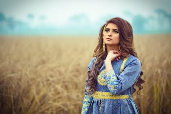 Brunette Haired Woman in Blue Dress Stranding in an Open Field