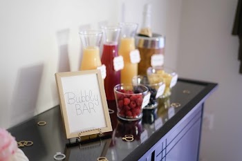 Bubbly Bar Sign With Several Assorted-color Liquid With Bottles on Top of Black Wooden Table