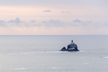 building on rocky cliff surrounded by the sea