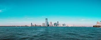 Buildings Beside Body of Water Under Blue Sky