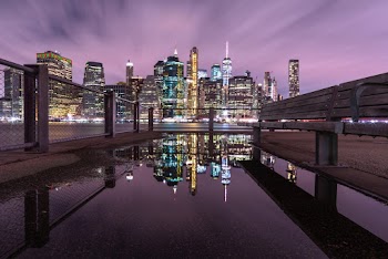 Buildings Reflecting On Puddle