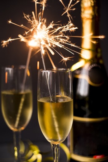 Burning sparkler in champagne glass on dark background Free Photo