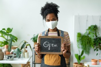 Business owner holding open sign in the new… | Free stock photo | High Resolution image