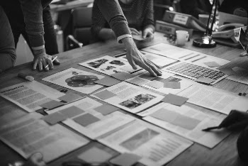 Business people brainstorming, documents on table | Free Photo - rawpixel