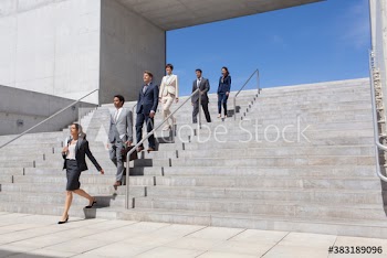 Business people descending sunny stairs