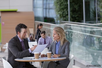 Business people discussing paperwork in cafeteria