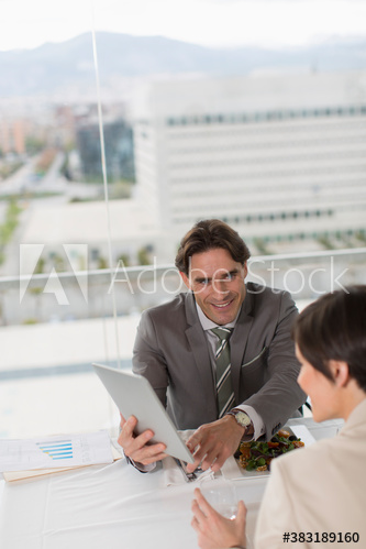 Business people eating lunch and using digital tablet in office
