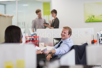 Business people exchanging paperwork in office