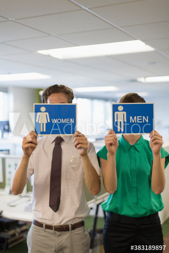 Business people holding men and women bathroom signs