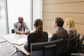 Business people interviewing businessman in conference room