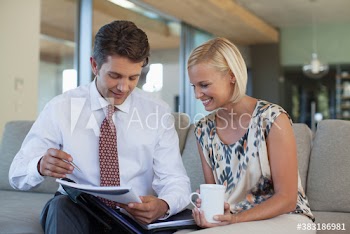 Business people reviewing paperwork on sofa