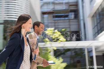 Business people running outside office building