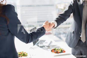 Business people shaking hands in sunny office