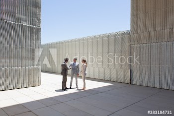 Business people talking in sunny modern courtyard