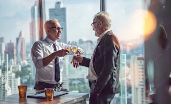 Business People Toast Success Achievement Colleagues Corporate while standing by windows.Business People cheering each other with champagne in a modern business lounge high up in an office tower.