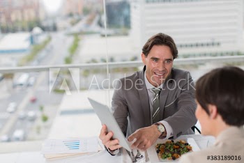 Business people using digital tablet at working lunch