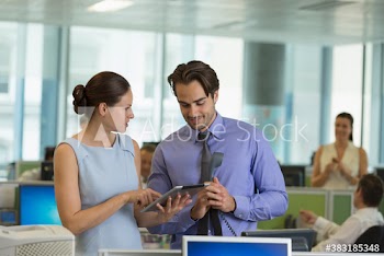 Business people using digital tablet in open plan office