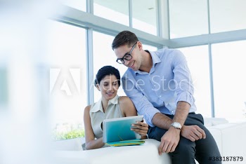 Business people using digital tablet on sofa