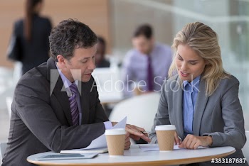 Business people with coffee discussing paperwork in cafe
