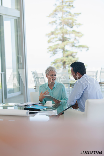 Business people with digital tablet talking in meeting