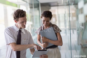 Business people with digital tablet talking in office