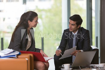 Business people with paperwork meeting in lobby