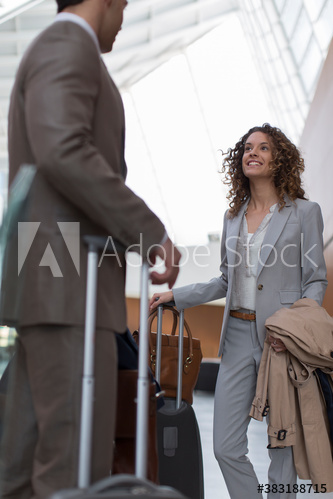 Business people with suitcases talking in airport
