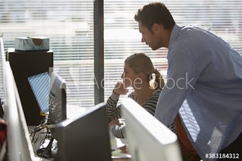 Business people working at laptop and computer in sunny office